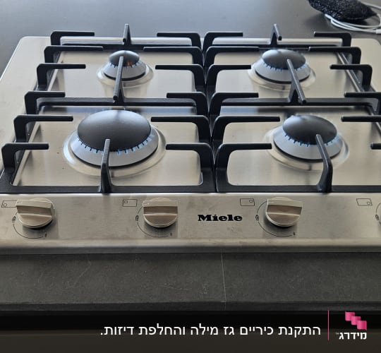 כיריים גז על משטח מטבח עם להבות דולקות